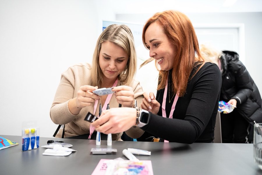 Účastnice workshopu si zkoušejí produkty u stolu